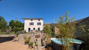 a house with a bath tub in a yard at Chez Pauline - Chambres d'hôtes Bourguignonnes in Prissé