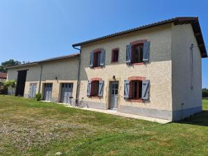 a house with red shuttered windows and a yard at Maison Céline - Jardin clos et Parking Privé Gratuit in Crevant-Laveine