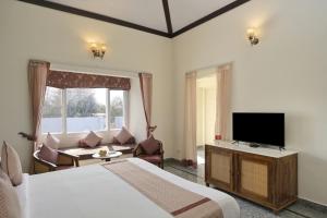 a hotel room with a bed and a flat screen tv at Trulyy The Jawai Leopard Kingdom in Jāmb