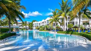 a swimming pool at a resort with palm trees at 131 Mariners Club in Key Largo