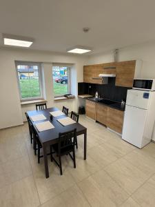 a kitchen with a table and a white refrigerator at Apartmány Papírna in Ostrov