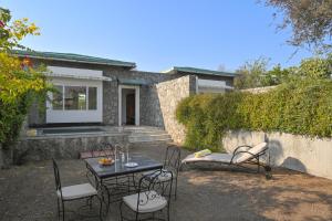 a patio with a table and chairs in front of a house at Trulyy The Jawai Leopard Kingdom in Jāmb