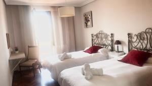 a hotel room with two beds and a window at Apartamentos Azafranal-PARKING GRATIS- in Salamanca
