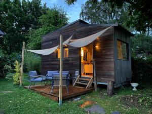 a small cabin with chairs and a table on a deck at Tiny House de Clara in Avrillé