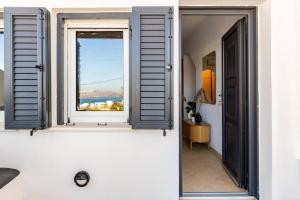 a window in a room with a view of the water at Aelia Suites Akrotiri, Santorini in Akrotiri