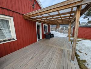 a wooden deck on the side of a red building at Villa Vilsam in Gällivare
