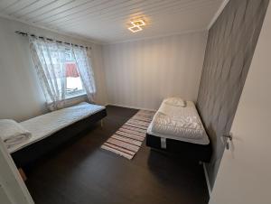 a small room with two beds and a window at Villa Vilsam in Gällivare