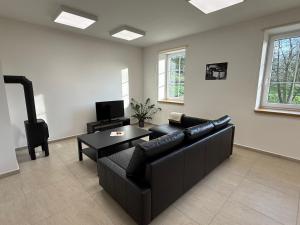 a living room with a black couch and a table at Apartmány Papírna in Ostrov