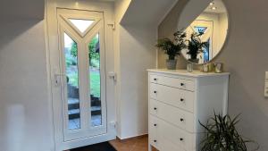 a white dresser with a mirror on top of it at Maarträumchen in Gillenfeld in Gillenfeld