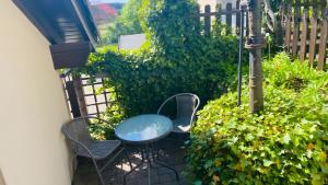 a patio with a table and chairs and a fence at Maarträumchen in Gillenfeld in Gillenfeld +3 photos