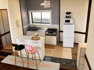 a small kitchen with white appliances and pink chairs at Amoria 2 in Miyazaki