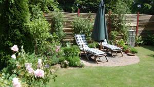 two chairs and an umbrella in a garden at Gartenhaus in Dodenburg in Dodenburg +8 photos