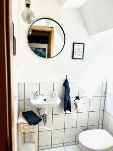 a bathroom with a sink and a mirror and a toilet at Historisches Ganghaus "Bluebelle" in Lübeck +37 photos