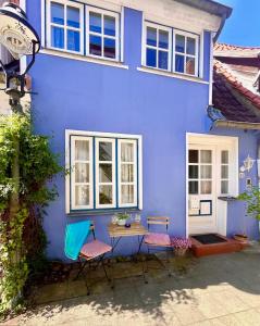 a blue house with chairs and a table in front of it at Historisches Ganghaus "Bluebelle" in Lübeck