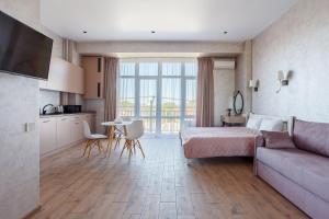 a bedroom with a bed and a table and a couch at Five seasons Family in Odesa