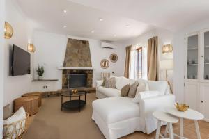 a living room with a white couch and a fireplace at Ca Ne Margalide - Andratx in Port d'Andratx