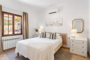 a white bedroom with a large bed and a mirror at Ca Ne Margalide - Andratx in Port d'Andratx +12 photos