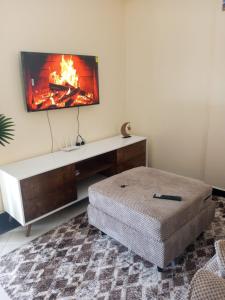 a living room with a tv on a wall at Mimi Home Stays in Voi
