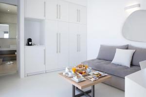 a living room with a couch and a table with food on it at Blue Vice Megalochori in Megalochori