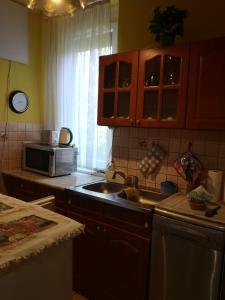 a kitchen with a sink and a microwave at Natasa Apartman in Orosháza