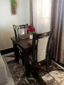 a dining room table and chair with flowers on it at Mimi Home Stays in Voi +7 photos