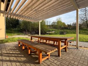 a wooden picnic table sitting under a pavilion at Apartmány Papírna in Ostrov