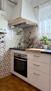 a kitchen with white cabinets and a stove at Refúgio Ribatejano in Alpiarça
