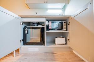 a small room with a microwave and a tv at Flexistays - Private En-Suite Studios - Kinnegad in Kinnegad