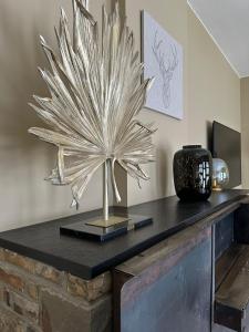 a table with a large metal plant on it at Le Quatre F in La-Roche-en-Ardenne