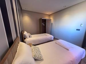 a hotel room with two beds and a window at Appartement 3 vue sur mer in Tamraght Ou Fella
