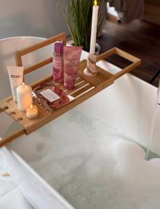a tray with candles and cosmetics sitting on a bath tub at Kapa Chalet Bran in Sohodol