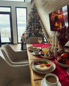 a room with a christmas tree and a table with food at Kapa Chalet Bran in Sohodol