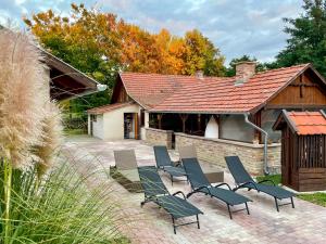 a group of chairs sitting on a patio in front of a building at Akácos Tanya Szarvas in Szarvas