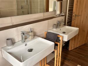 a bathroom with two white sinks and a mirror at Ferienwohnung Hafenblick in Neumagen-Dhron +26 photos