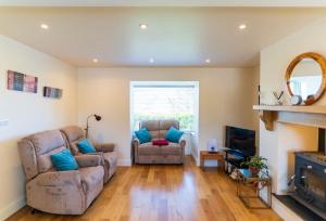 a living room with two chairs and a television at Mariner's Rest - Cahersiveen in Cahersiveen
