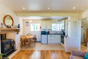 a kitchen with white cabinets and a table and chairs at Mariner's Rest - Cahersiveen in Cahersiveen