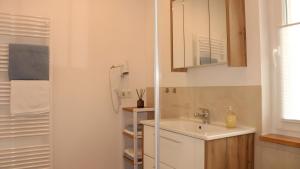 a white bathroom with a sink and a shower at Ferienhaus am Mühlteich in Neuhaus-Schierschnitz +17 photos