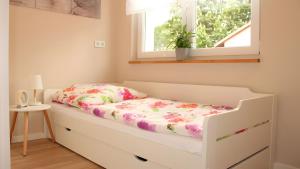 a bed in a room with a window at Ferienhaus am Mühlteich in Neuhaus-Schierschnitz