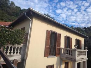 a white building with brown shutters and a balcony at B&B Luna in Sesto Calende