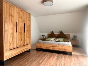 a bedroom with a bed and a large wooden cabinet at Ferienwohnung Hafenblick in Neumagen-Dhron