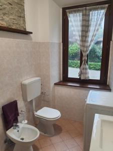 a bathroom with a toilet and a sink and a window at B&B Luna in Sesto Calende +10 photos