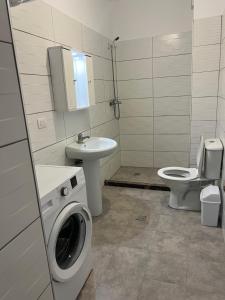 a bathroom with a washing machine and a toilet at Apartments Kristi in Shëngjin +30 photos