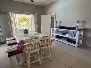 a kitchen with a table and chairs in a room at Eight Umdoni North in Pennington