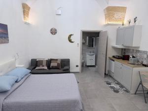 a small bedroom with a bed and a kitchen at Monolocale Central Station in Brindisi