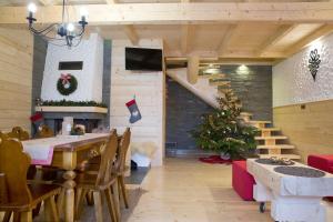 a dining room with a table and a christmas tree at Domki letniskowe całoroczne in Mizerna