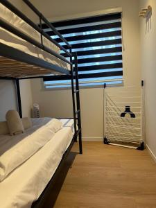 ein Schlafzimmer mit zwei Etagenbetten und einem Fenster in der Unterkunft Tiny House Cinta- Dichtbij zee & in een groene omgeving in Heinkensand