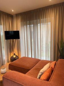 ein Schlafzimmer mit zwei Betten und einer Couch vor einem Fenster in der Unterkunft Tiny House Cinta- Dichtbij zee & in een groene omgeving in Heinkensand