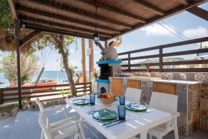 a table and chairs on a patio with a view of the ocean at Apágkio Filoxenia in Archangelos