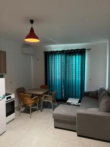 a living room with a couch and a table with chairs at Apartments Kristi in Shëngjin