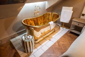 a bathroom with a gold tub on display at Bowburn Hall Hotel in Durham +74 photos